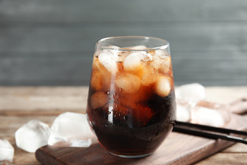 Composition with glass of refreshing cola on table