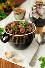 Cooked legumes meat in a bowl on an old wooden table. National dish Asia, Europe, America
