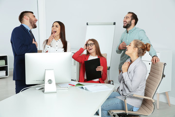 Group of office employees laughing in conference room