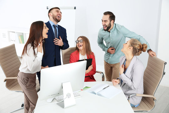 Group of office employees laughing in conference room