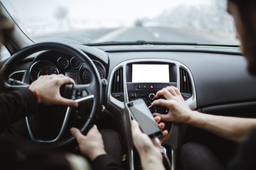 The man holds the phone in his hand. In the car