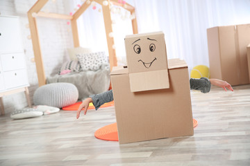 Fototapeta premium Cute little child wearing cardboard costume in bedroom
