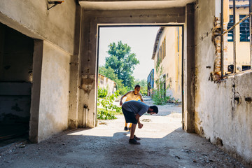 Two attractive sporty young men training parkour outdoor