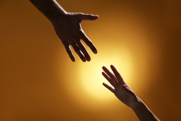 Man reaching for woman's hand on color background, closeup. Help and support concept