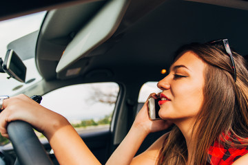 Fototapeta na wymiar Businesswoman talking on the phone in the car while driving reckless