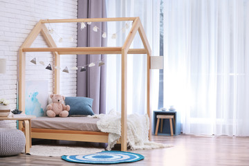 Stylish child room interior with cute wooden bed