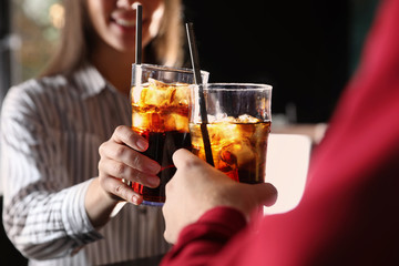 Young couple with glasses of refreshing cola indoors, closeup © New Africa
