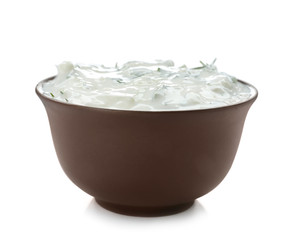 Bowl with cucumber sauce on white background
