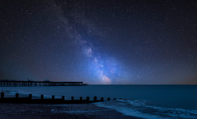 Vibrant Milky Way composite image over landscape of pier under construction and development