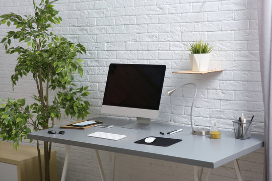 Interior of comfortable work place with computer on table at home