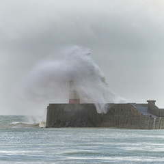 Fototapeta na wymiar Stunning dangerous high waves crashing over harbor wall during windy Winter storm at Newhaven on English coast