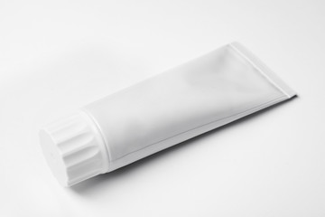Blank tube of toothpaste on white background