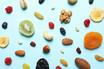 Flat lay composition of different dried fruits and nuts on color background