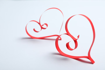 Hearts made of paper strips on white background