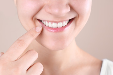 Young woman with beautiful smile on color background, closeup