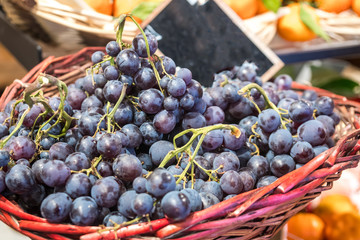 Red grapes and various fruits in the market