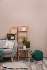 Modern eco style interior of living room with wooden crates and sofa near color wall