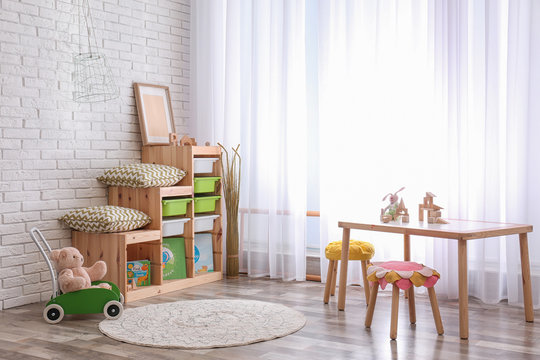 Modern eco style interior of child room with wooden crates near brick wall