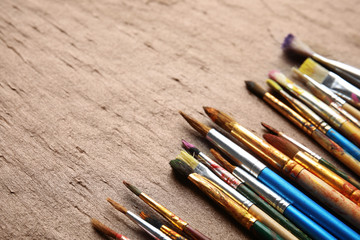 Obraz premium Different bright paint brushes on color table. Space for text