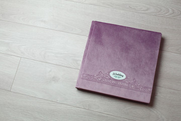 pink photo book with  fabric cover..
Photo book on a light background.

Photo album with a hard cover on a wooden background.
Bright  photo album.

