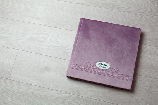 pink photo book with  fabric cover..
Photo book on a light background.

Photo album with a hard cover on a wooden background.
Bright  photo album.

