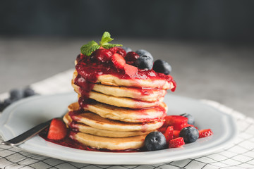 Pancakes with berries and sauce on plate. Toned image. Tasty pancakes © Vladislav Noseek