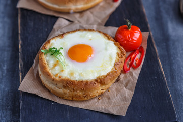 Cheese filled brioche with egg yolk and baked tomato