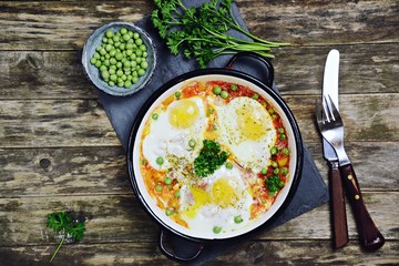 Delicious Shakshuka on the wooden background. Healthy eggs breakfast 