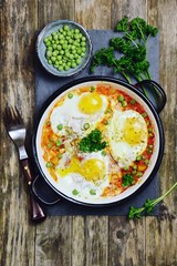 Delicious Shakshuka on the wooden background. Healthy eggs breakfast 