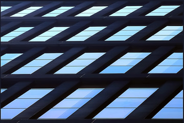 Geometric architectural background of blue. Skyscraper glass windows.
