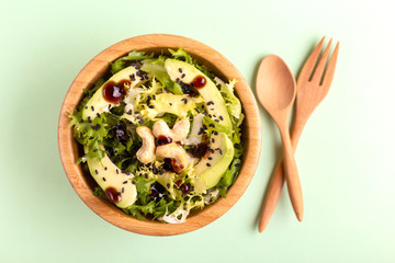 Tasty salad with frisee, avocado, cashew nuts and black sesame