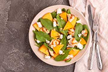 Exotic salad with spinach, persimmon, grilled chicken fillet, feta