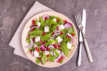 Healthy salad with spinach, arugula, red onion and pomegranate