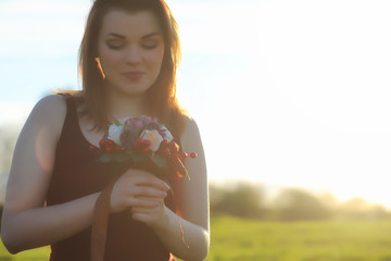 A girl in a hat on a walk in the park. A girl with a basket walks in the spring. A girl is walking along the road at sunset.