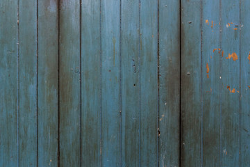 Full frame background of an old, faded and dirty wood board wall painted in blue.