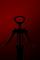 Glass blue bottle with a corkscrew in a dark key on a colored background. A bottle of wine.