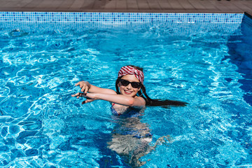 Beautiful teenage girl relaxing in pool water