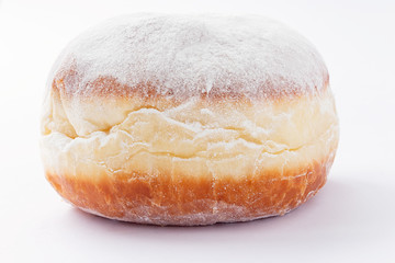 One freshly made doughnut filled with jam and covered in powdered sugar on a white background