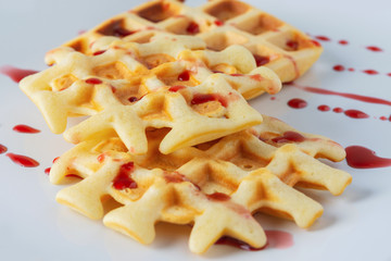 Viennese, Belgian waffles on a white plate. Cherry topping. Close up. Selective focus.