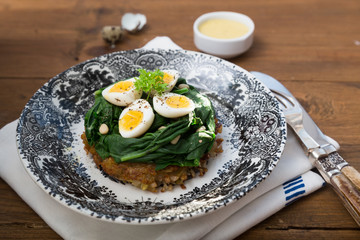 Rosti topped with spinach and quail eggs