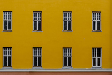 Fototapeta premium Closeup photo of bright yellow building with eight windows