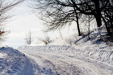 Fototapeta na wymiar white snowy road and black tree branches