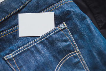 Close up of blank white business card in jeans pocket. Empty space.
