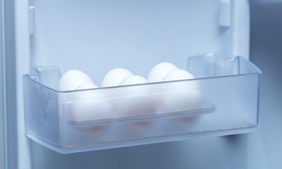 Fototapeta na wymiar chicken eggs on a plastic tray in the fridge