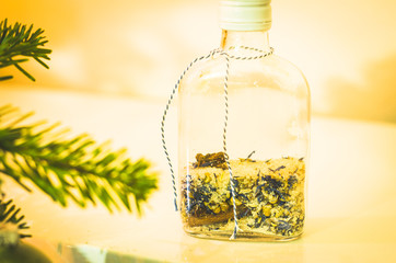 Bottle mail filled with sand and spices and green branches