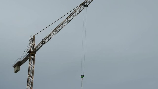 Gr&uacute;a de construcci&oacute;n en movimiento giratorio, elevando gancho con cadenas