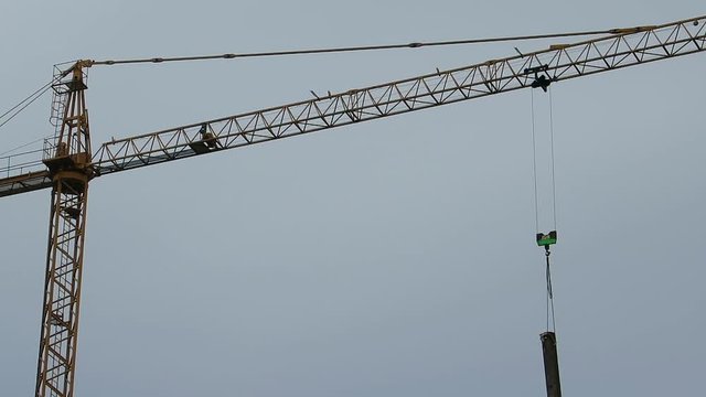 Gr&uacute;a de construcci&oacute;n girando y a la vez bajando material de construcci&oacute;n