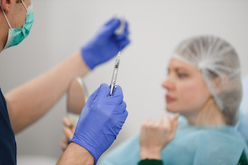 girl do plastic operation in medical clinic; doctor does lip augmentation surgery; injecting...