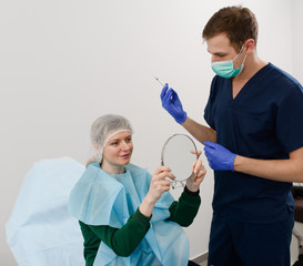 girl do plastic operation in medical clinic; doctor does lip augmentation surgery; injecting...