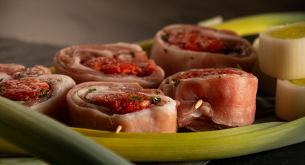 raw meat rolls on skewers, on green leaves, close-up